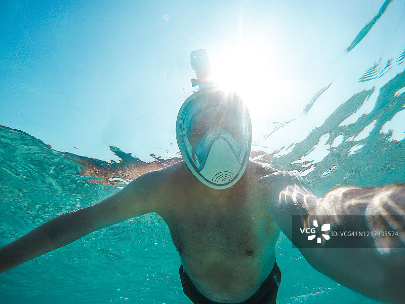 戴面罩的人在清澈的水中潜水图片素材
