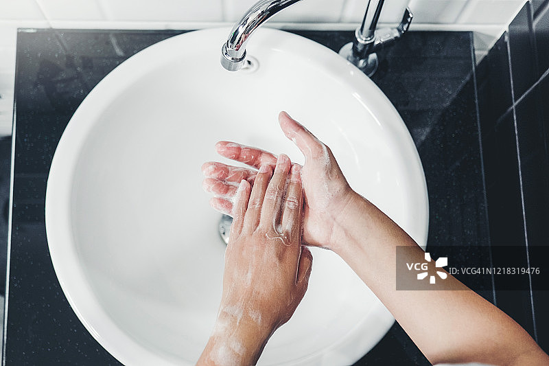 亚洲妇女用肥皂彻底洗手，以预防冠状病毒图片素材