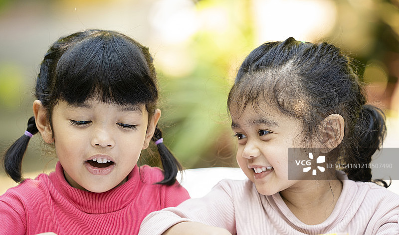姐姐笑着一起幸福。儿童的自然面部表情与家庭关系概念。图片素材