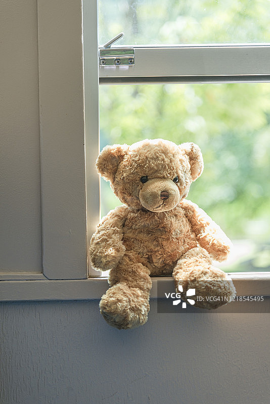 泰迪熊坐在火车窗户上图片素材