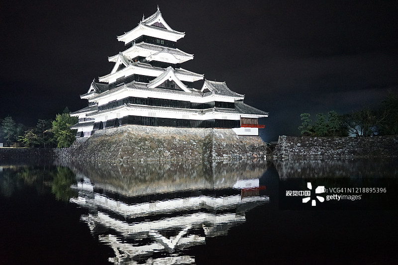 美丽的黑白松本城堡与明亮的灯光在夜晚图片素材