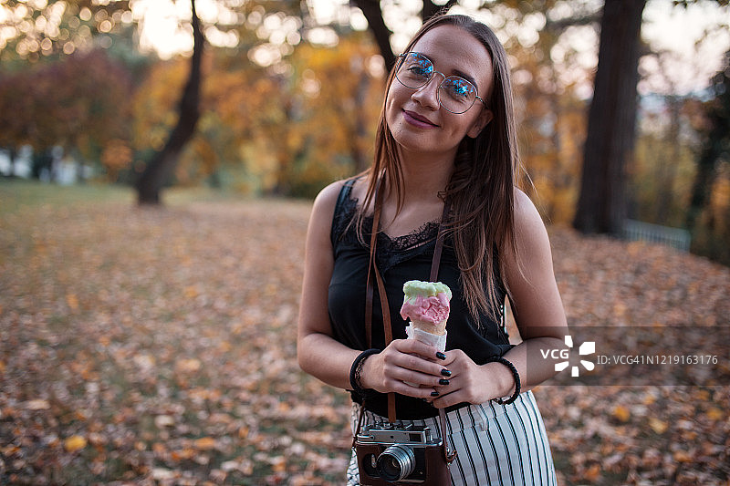 年轻女子在公园里吃冰淇淋图片素材