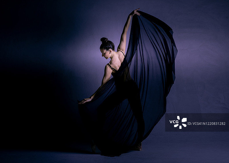 芭蕾舞女演员在黑暗的照相馆里跳舞图片素材
