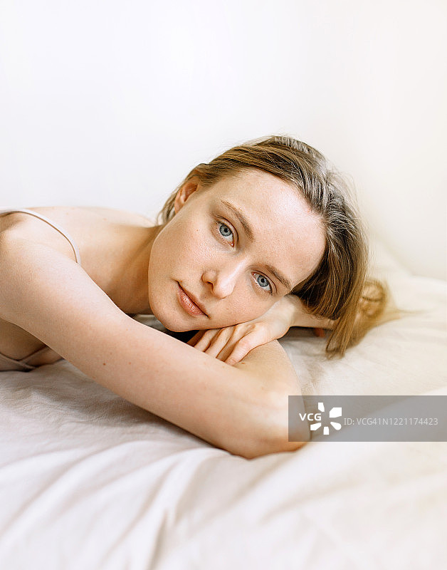 年轻白人女人在床上微笑的特写图片素材