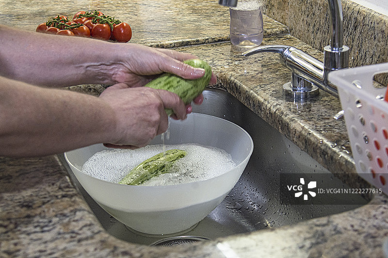 特写的手，洗蔬菜在家庭厨房水槽图片素材