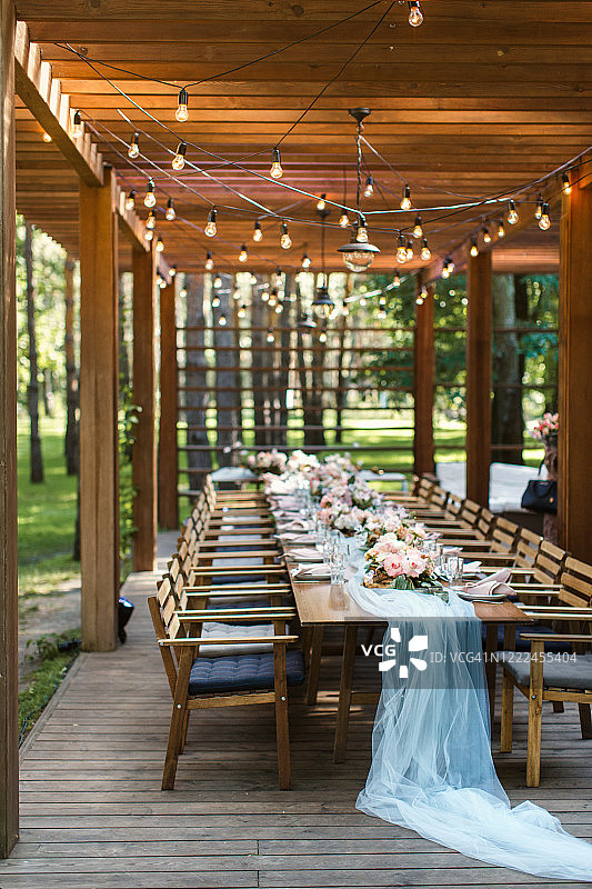 森林里一家餐厅阳台上的一张质朴的婚礼餐桌图片素材