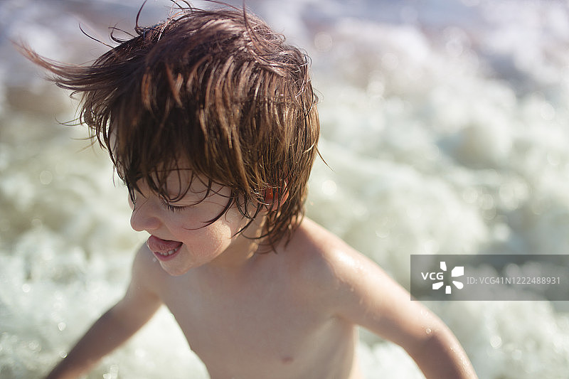 海滩上那个头发乱蓬蓬的男孩图片素材