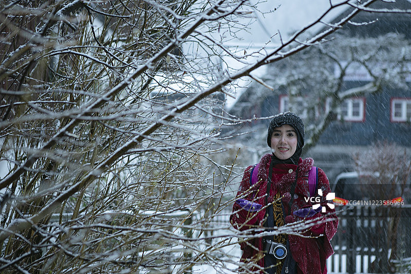 亚洲穆斯林游客在哈尔斯塔特享受冬天的雪图片素材