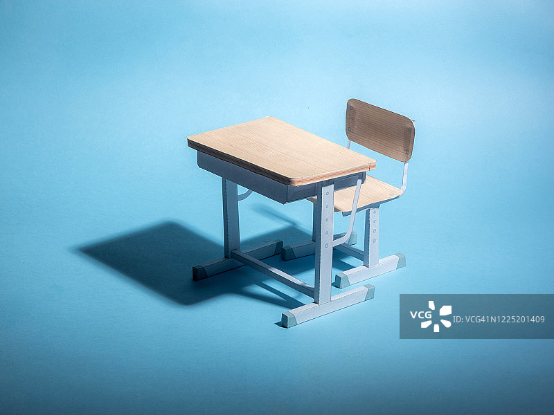 蓝色背景下的空课桌。概念。图片素材