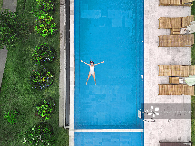 鸟瞰图有吸引力的女人浮在水上在度假胜地图片素材