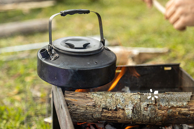 茶壶在露营的壁炉上暖着。图片素材
