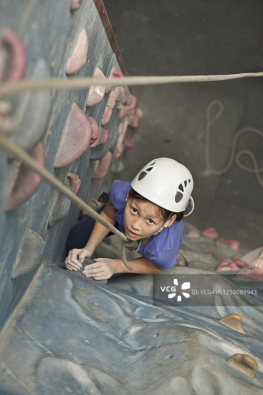在英国，一个小女孩在爬室内攀岩墙图片素材