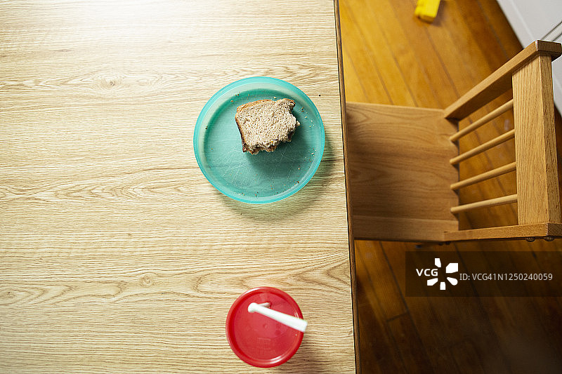 花生酱三明治放在五颜六色的儿童盘子里，空着椅子图片素材