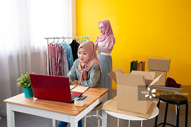 年轻的穆斯林妇女戴着头巾创业，在家为网上零售店工作图片素材