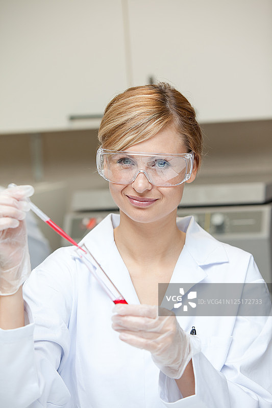 一个女性科学家把液体放在试管与吸管的特写图片素材