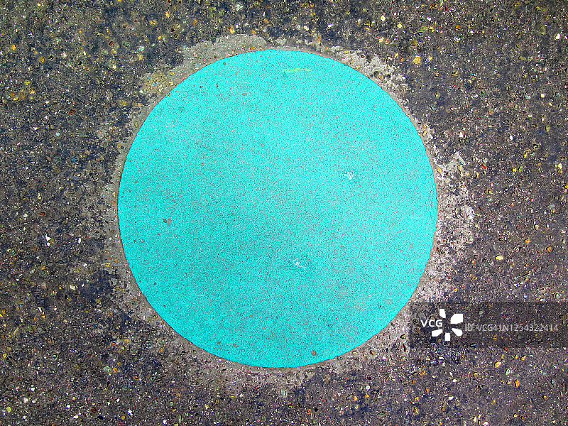 风化的绿色圆圈画在街道的沥青上图片素材
