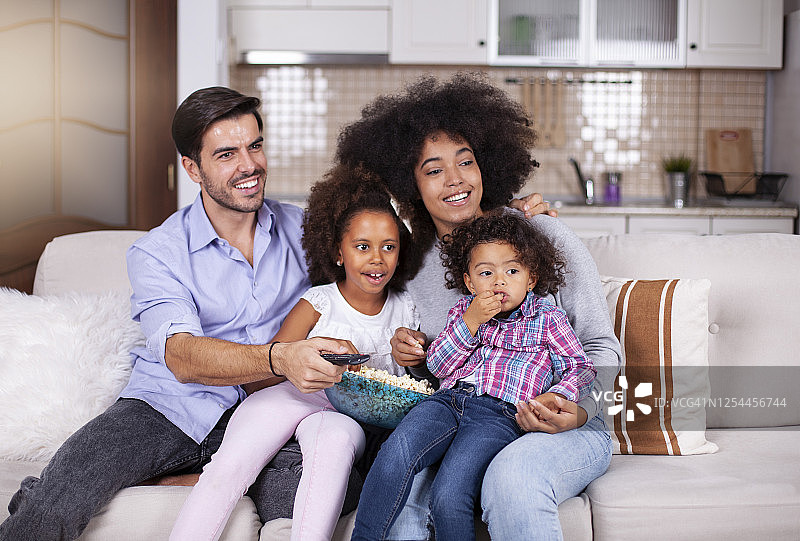 欢乐的非裔美国家庭一边看电视一边吃爆米花图片素材