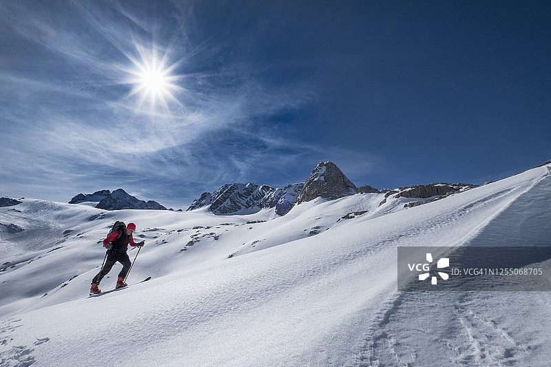 晴朗的一天，奥地利，一名男子在覆盖着积雪的达赫斯坦山上滑雪图片素材