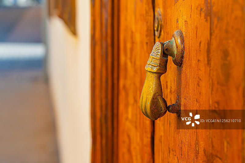 旧木门上的黄铜手门环。木雕门与生锈的手门环。图片素材