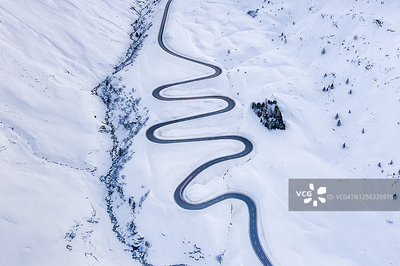 瑞士雪中的朱利安山口路的弯道图片素材