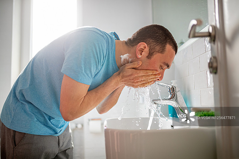 男人刮胡子后在洗脸图片素材