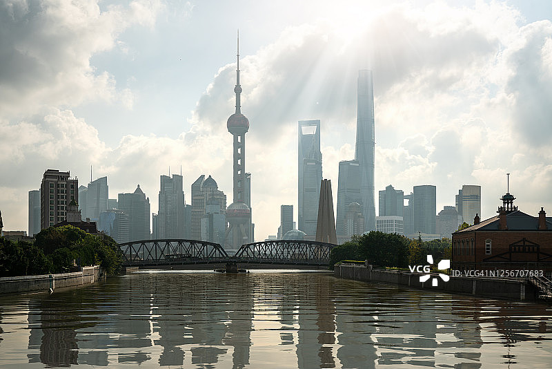 东方明珠塔和陆家嘴商务区摩天大楼与黄浦江在中国上海的浦东天际线。亚洲旅游，现代城市生活，或商业金融经济概念图片素材