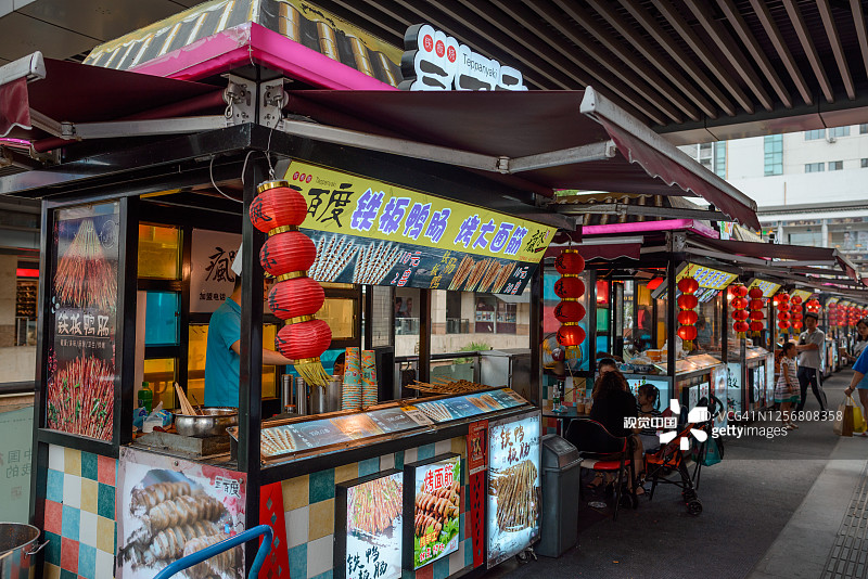 中国的街边小吃摊。小贩烹饪和销售图片素材