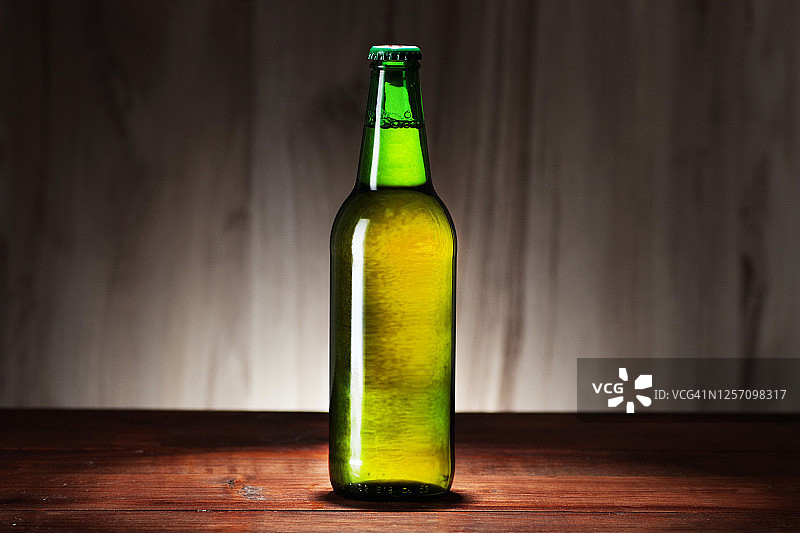在面板的背景上放着一瓶绿色的啤酒图片素材