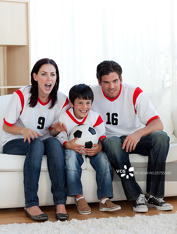 父母和他们的儿子在看足球比赛图片素材