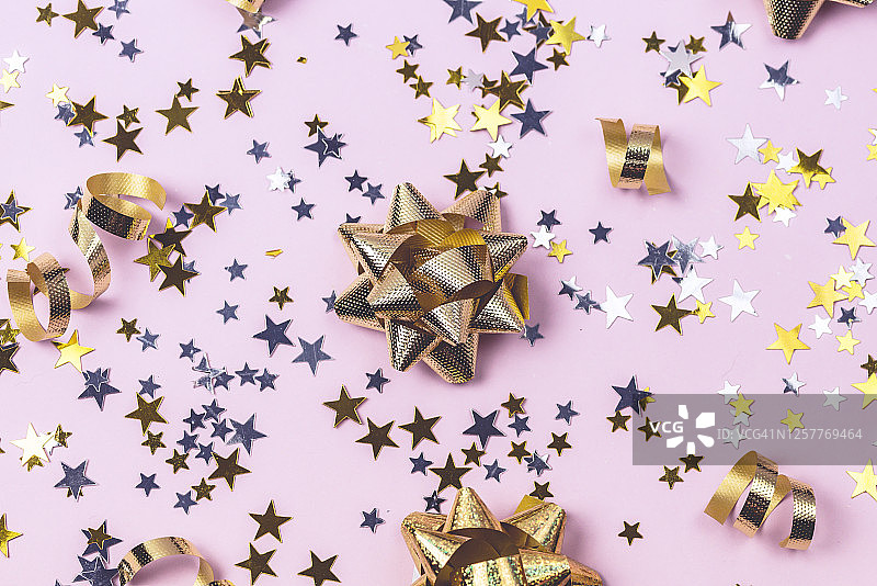 金色和银色的五彩纸屑在粉红色的背景上闪闪的背景假日庆祝概念节日背景新年图片素材