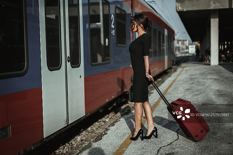 拎着皮箱上火车的时髦女人图片素材