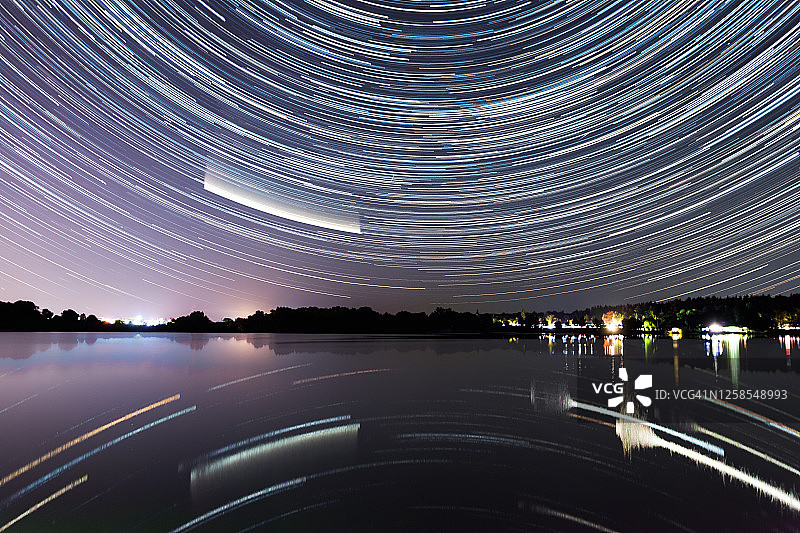 星星在湖面上划过。彗星Neowise C/2020 F3夜间在湖上。图片素材