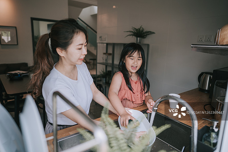 一位亚洲华人妈妈和她的女儿在厨房洗盘子图片素材
