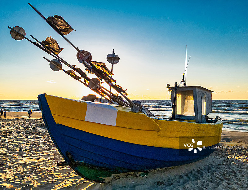 日落时分波罗的海海滩上的木制渔船。图片素材