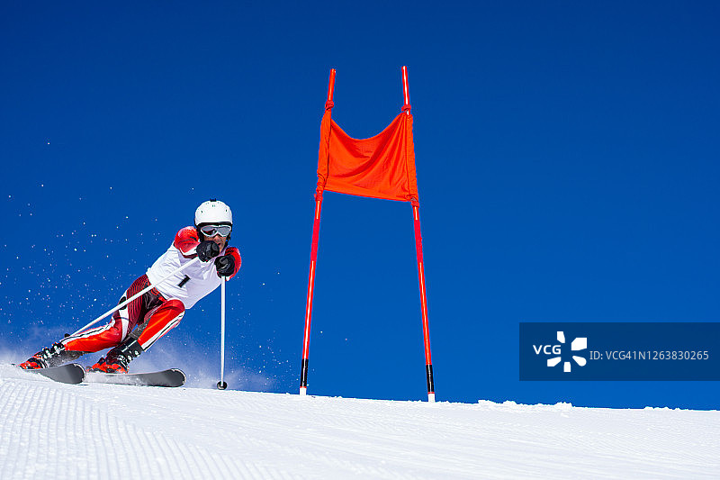 专业高山滑雪者在晴朗的蓝天上滑雪图片素材