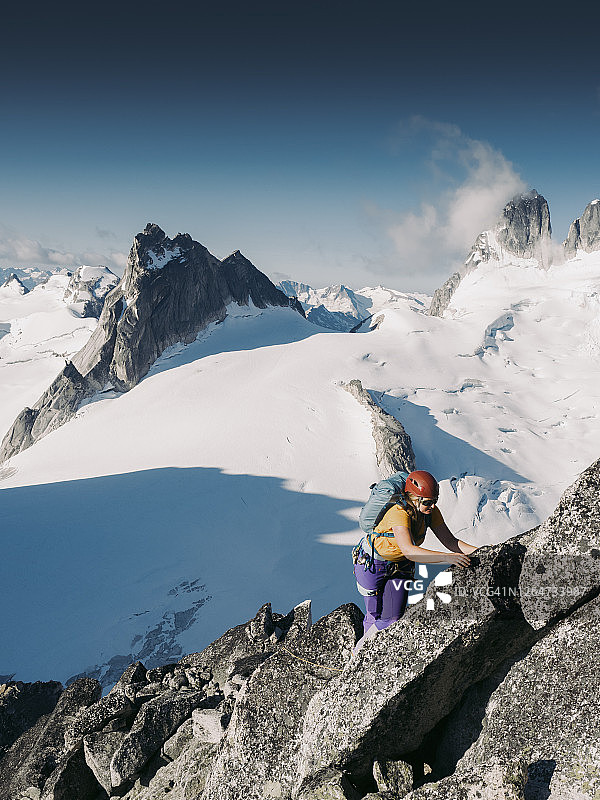 女攀岩者正在攀登Bugaboo尖塔上冰川上方的刀锋脊图片素材