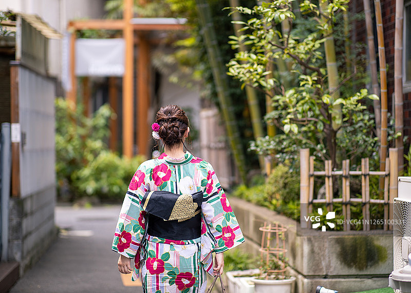 年轻女子在浴田探索古老的日本城镇图片素材