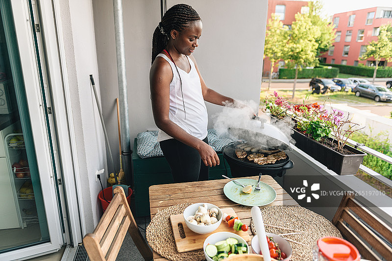 女人准备烧烤，用素食串，羊肉和香肠在电烤架上图片素材