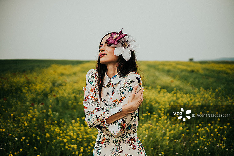 女子在大自然中穿着长花图案连衣裙图片素材