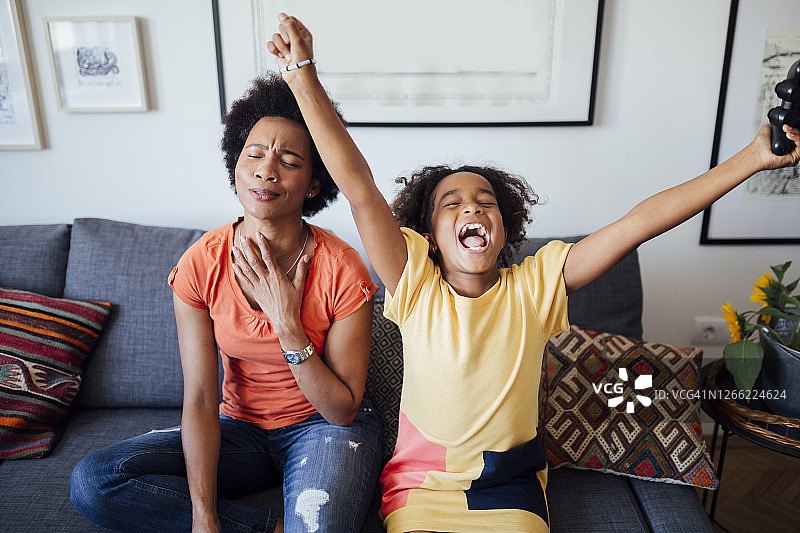 快乐的非裔美国母女在家里玩电子游戏图片素材