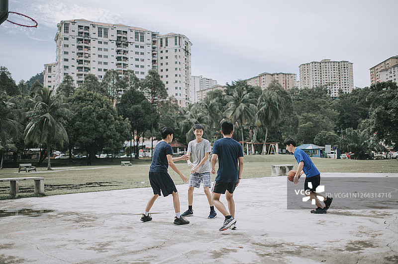 一群十几岁的亚裔中国男孩放学后在篮球场上打篮球图片素材