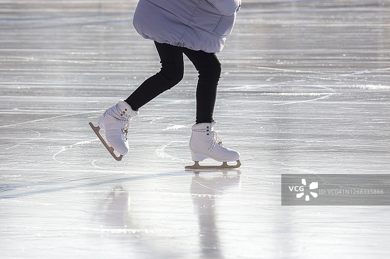 女孩在溜冰场滑冰。爱好和休闲。冬季运动图片素材