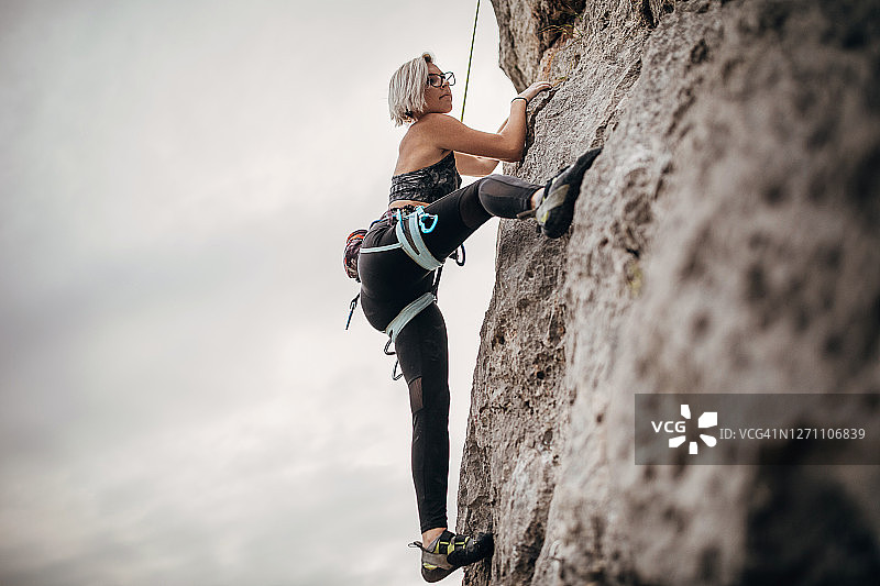 一名年轻的女性自由攀登者正在攀登岩石图片素材