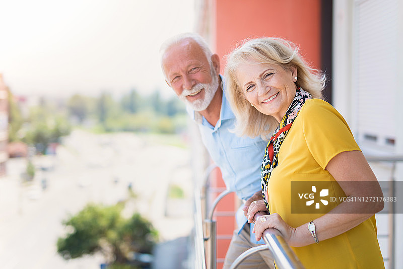 快乐的老夫妇从阳台看风景。图片素材