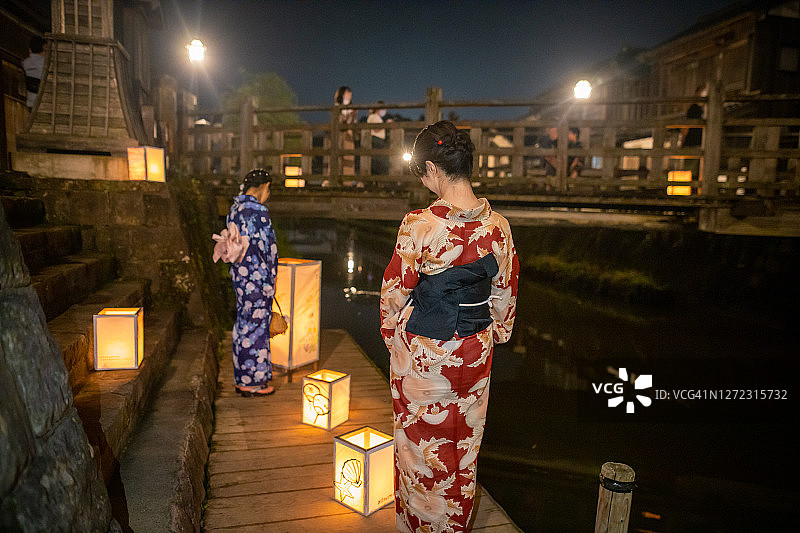 母亲和女儿在浴田看纸灯笼在传统的日本牛郎长崎节图片素材