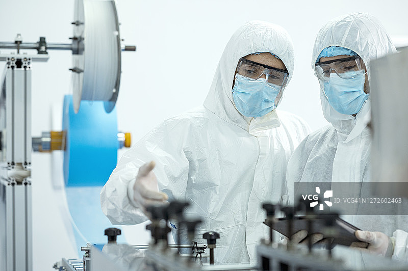 医用口罩厂采用数字化平板电脑和自动化生产线。生产、开发技术。图片素材