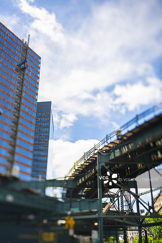 纽约地铁在昆斯伯勒广场的高层办公大楼之间的高架轨道上运行。图片素材