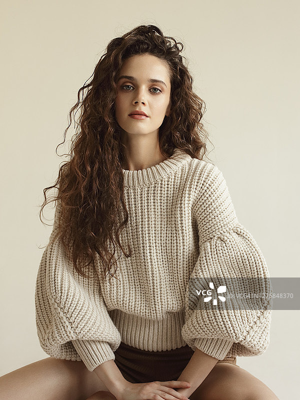 年轻漂亮的女人穿着米色毛衣图片素材