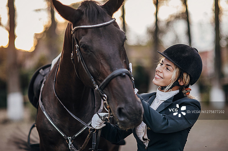 女骑师拥抱她的马后训练在骑马学校图片素材