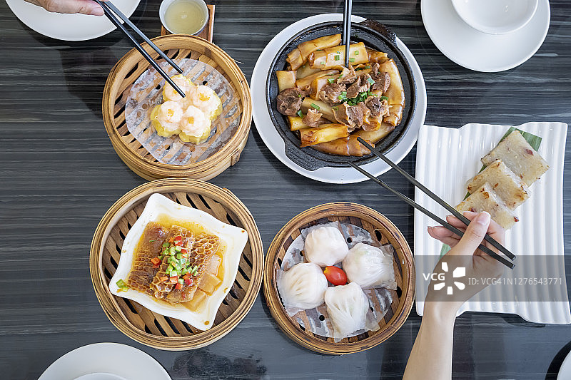 人们在餐馆里用筷子吃广东dum sum图片素材